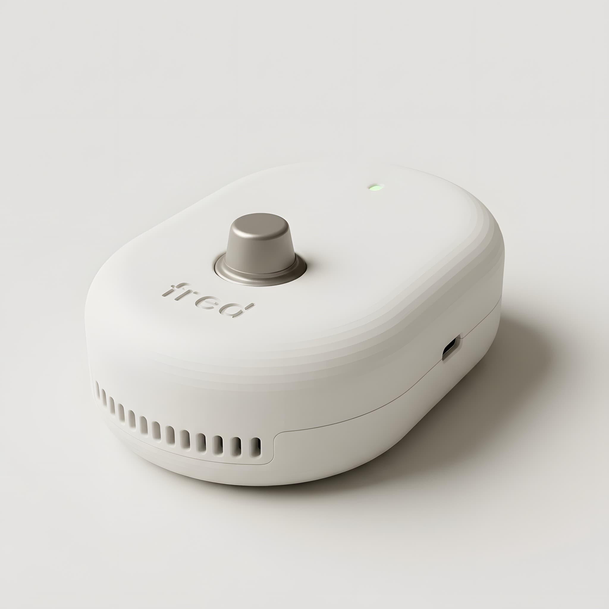 Fred, un sensor de cocina blanco y ovalado, con el sensor de gas arriba, un LED verde encendido y la palabra fred grabada